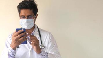 ung, manlig läkare bläddring internet på smartphone video