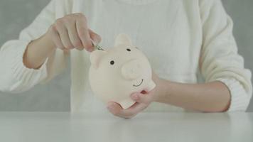 Save money. business woman putting coin into piggy bank for saving. wealth, Finance, business, investment, retirement, future, accounting, plan life, economize, banking, family, health. video