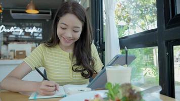 inspiration, écrivain, écriture, création, loisirs pour imaginer, belle jeune femme asiatique séduisante écrivant des idées sur un cahier, liste de choses à faire, bon travail de réflexion, journaliste, élégant, image de rêve, détente video