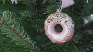 Christmas tree with pink donut decoration - close shot video