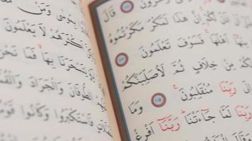 lento movimiento ver de el página de el santo islámico libro, Corán es un religioso libro con el Arábica alfabeto, musulmanes leer Corán mientras Orando video