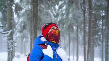 ensam turist flicka gående på en vinter- snötäckt barr- skog i de berg. frostig väder. långsam rörelse video