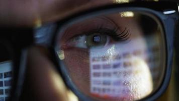 mulher dentro óculos olhando em a monitor e surfar Internet. a monitor tela é refletido dentro a óculos video