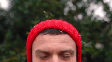 Portrait of a man in a red cap in snowy weather outdoors video