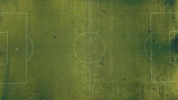 Aerial view of football team practicing at day on soccer field in top view video