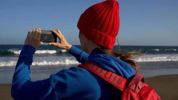 actief wandelaar vrouw wandelingen Aan de strand naar de water. Kaukasisch jong vrouw met rugzak Aan tenerife, kanarie eilanden video