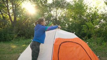 femme est en mettant une touristique tente dans le forêt video