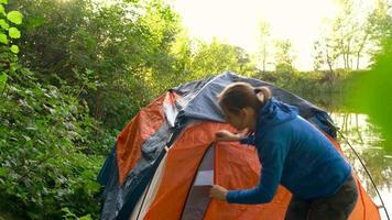 femme est en mettant une touristique tente dans le forêt video