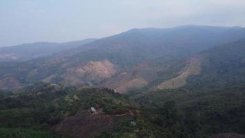 montaña destruido por humano para cultivar plantas. aéreo ver de montañas cubierto en calina desde ardiente bosques areas con denso niebla tóxica y cubierto con pm2.5. aire contaminación y ecológico problemas video