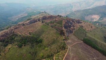 montaña destruido por humano para cultivar plantas. aéreo ver de montañas cubierto en calina desde ardiente bosques areas con denso niebla tóxica y cubierto con pm2.5. aire contaminación y ecológico problemas video