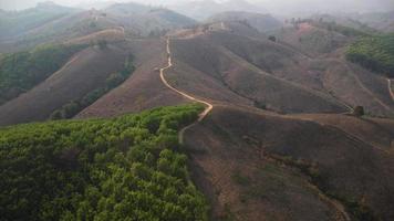 Mountain destroyed by human for cultivate plants. Aerial view of mountains covered in haze from burning forests. Areas with dense smog and covered with PM2.5. Air pollution and ecological problems video