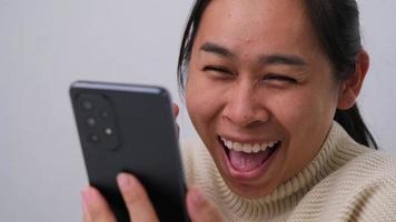 Portrait of happy woman enjoying success on mobile phone at home. Close-up of happy young woman reading good news on the phone. Surprised woman celebrating success on the phone. video