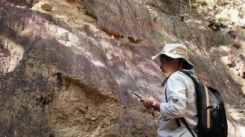 la geóloga que usa una lupa examina la naturaleza, analizando rocas o guijarros. los investigadores recolectan muestras de materiales biológicos. Investigación ambiental y ecológica. video