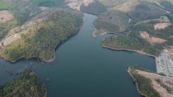 Water dam and lake reservoir panoramic aerial view on the hills of northern Thailand. Aerial view on mountain lake. Drone over water reservoir at mountain valley covered with green spring forest. video