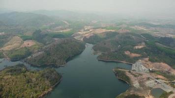 acqua diga e lago serbatoio panoramico aereo Visualizza su il colline di settentrionale Tailandia. aereo Visualizza su montagna lago. fuco al di sopra di acqua serbatoio a montagna valle coperto con verde primavera foresta. video