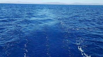 Summer holiday concept. The endless blues of the Aegean. View from the board of a moving yacht. Natural sky and horizon background video