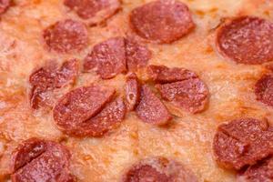 Delicious fresh pepperoni pizza with sesame seeds on the sides photo