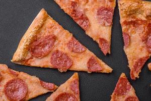 Delicious fresh pepperoni pizza with sesame seeds on the sides photo