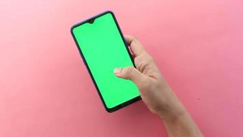 young man hand using smart phone with green screen video