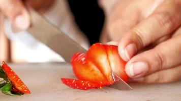 jong Dames snijdend rijp rood aardbeien met mes , video