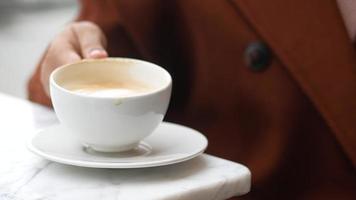 donne Tenere un' caffè tazza su tavolo , video