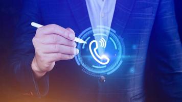 Contact us or Customer support hotline people connect, Businessman using showing and touching on virtual screen call phone icons contact. photo