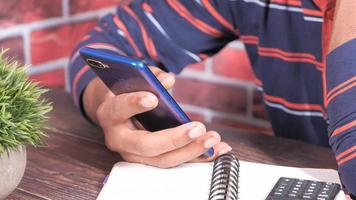 top view of man hand using smart phone on office desk video