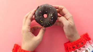 vrouw hand- Holding vers donuts dichtbij omhoog video