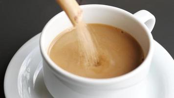 pouring brown sugar in a coffee cup , video