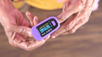 Senior young woman hand using pulse oximeter. video