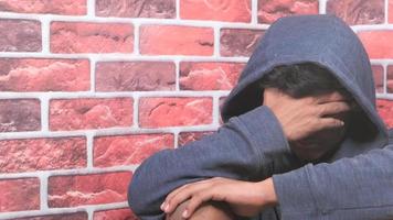 traurig Mann im Kapuze Startseite Gesicht mit Hände video