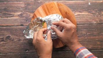 Man guest unwraps delicious fresh hamburger at wooden table video