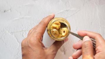 Man scooping marinated canned mushrums in glass pot video