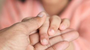 far håller handen av baby barn, närbild. video