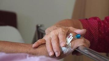 Wife visiting husband in hospital. Senior couple holding hands on hospital bed for hospitalization for supporting his dear. Concept of love and to be with lover. video