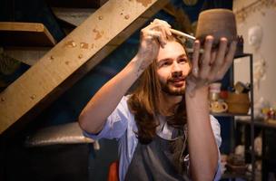 Pottery artist, Young making a piece of clay molding calmly and meticulously In order to produce the most attractive work possible, photo