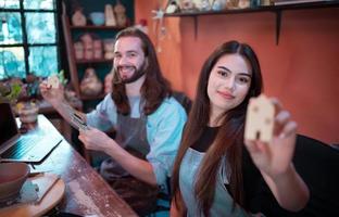 Two young entrepreneurs who own a pottery business. generate enough income from the business to expand the business to accommodate the increasing number of customers photo