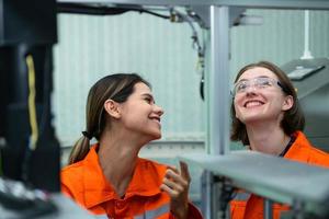 Both of woman in an electronic parts factory Using a production line controller and are recommending colleagues to use this tool. photo
