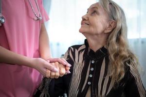 cuidador para un mayor mujer semanal chequeos a el del paciente residencia. Listo a dar médico Consejo y hablar acerca de varios cuentos, intercambiar cada otro felizmente. foto