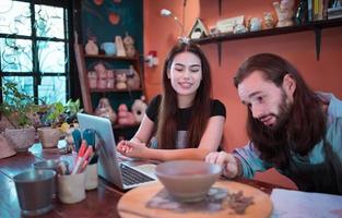 Two young entrepreneurs who own a pottery business. We are discussing the container that the customer wants to be molded. to be used to decorate the house photo