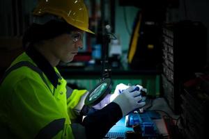 The technician must use bright lights and a magnifying glass to check the detail of the workpiece. the 3D printer's printout. photo