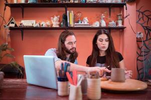 Two young entrepreneurs who own a pottery business. We are discussing the container that the customer wants to be molded. to be used to decorate the house photo