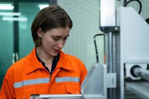 Young woman in an electronic parts factory Using a production line controller and are recommending colleagues to use this tool. photo