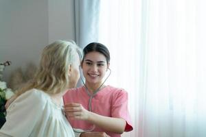 cuidador para un mayor mujer semanal chequeos a el del paciente residencia. Listo a dar médico Consejo y hablar acerca de varios cuentos, intercambiar cada otro felizmente. foto