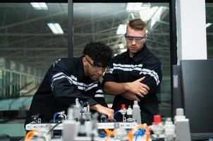 el robótico mano tecnología profesor es instruyendo nuevo estudiantes en cómo a utilizar electrónico circuito tableros y robótico mano comandos para un variedad de industrial aplicaciones foto