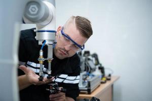 estudiantes estudiando robótico mano tecnología son aprendizaje cómo a construir robótico manos para un rango de industrial usos. foto