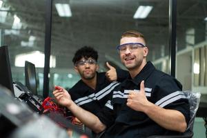 The robotic hand technology teacher is instructing new students on how to use electronic circuit boards and robotic hand commands for a variety of industrial applications. photo