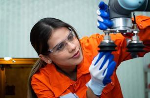 In an electronic parts facility, Female engineers In the plant, inspecting and testing robotic hands used in the production of electronic components. photo