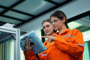 Both of woman in an electronic parts factory Using a production line controller and are recommending colleagues to use this tool. photo