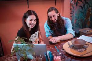 Two young entrepreneurs who own a pottery business. generate enough income from the business to expand the business to accommodate the increasing number of customers photo